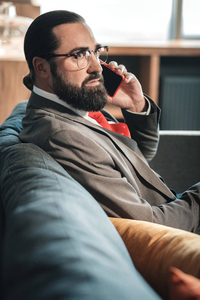 Handsome mature man wearing red tie calling his business partner - Foto, afbeelding