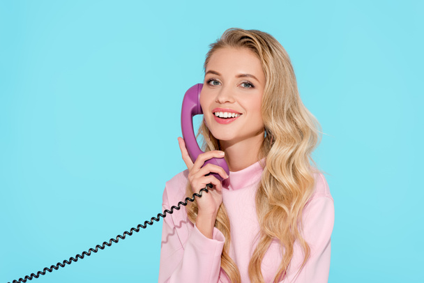 beautiful woman talking on vintage telephone with turquoise background - Photo, Image