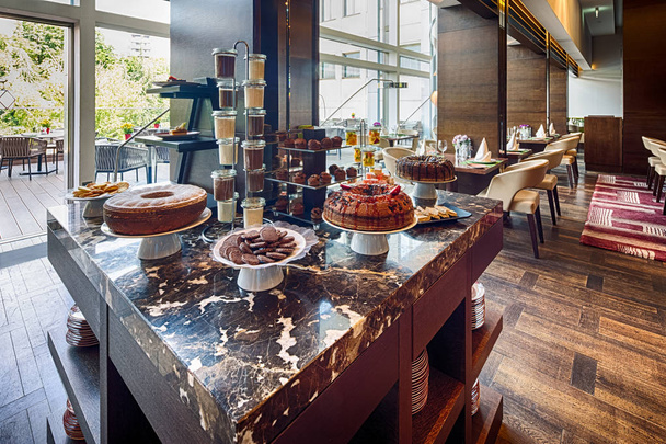 солодкий стіл в інтер'єрі ресторану сучасного готелю
 - Фото, зображення