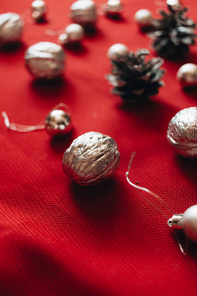 flat lay of silver balls and pine cones on red background, Christmas pattern - Foto, immagini