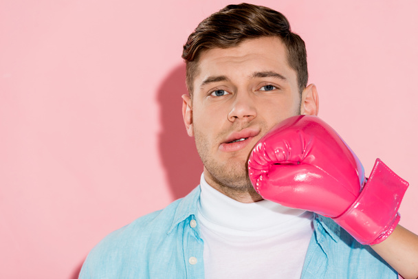 cropped woman in pink boxing glove hitting man in face on light pink background - Foto, imagen