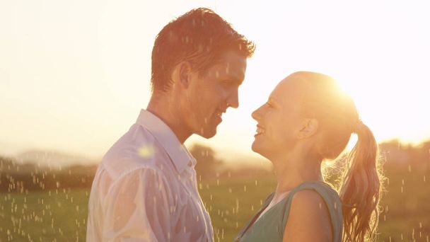 Close Up, odlesk objektivu: Žena a muž se těší nádherné letní večer v přírodě. Krásný mladý pár tance přes chladné jaro sprcha během jejich romantické rande. Přítel a přítelkyně - Fotografie, Obrázek