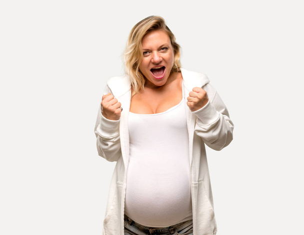 Pregnant blonde woman with white sweatshirt annoyed angry in furious gesture on isolated grey background - Valokuva, kuva