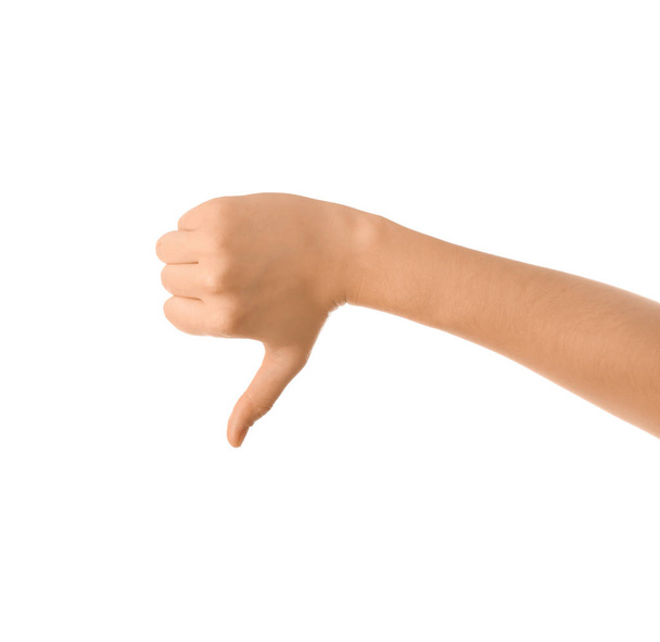 Mano femenina mostrando gesto de pulgar hacia abajo sobre fondo blanco
 - Foto, Imagen