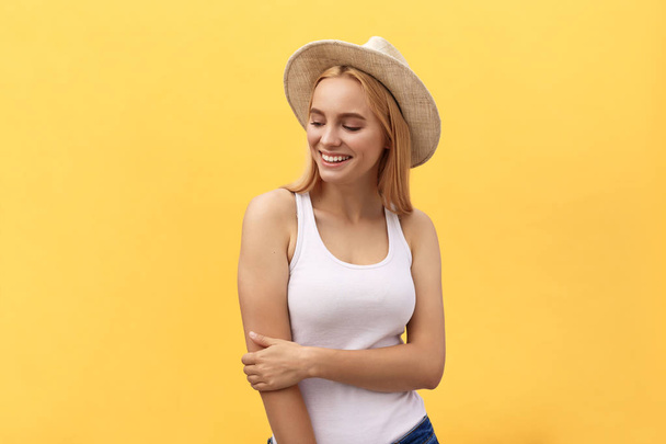 Young charming blond woman with happy exited emotional face looking at camera, isolated over yellow background - Photo, image