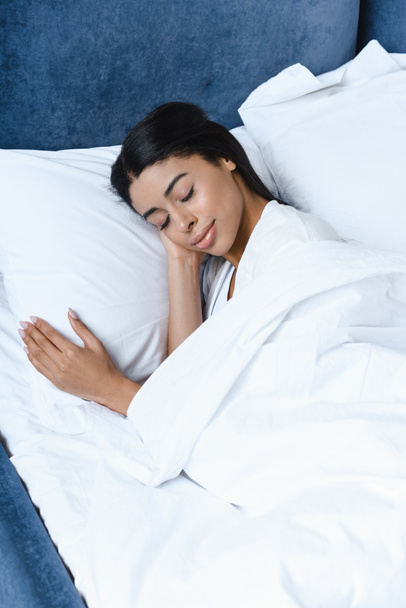 magas szög kilátás gyönyörű vegyes verseny lány reggel ágyban alszik - Fotó, kép