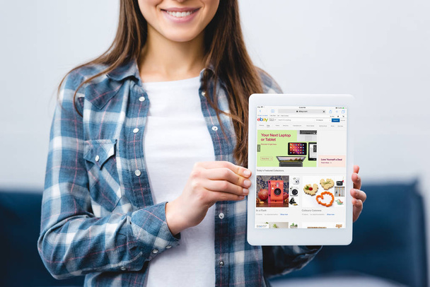 cropped shot of smiling girl holding digital tablet with ebay app - 写真・画像