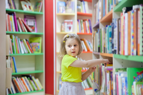  preschooler  choosing books at   library. - Fotoğraf, Görsel