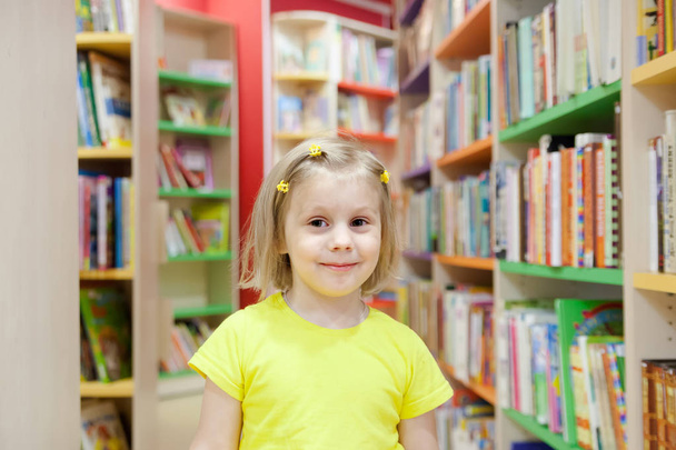  pré-escolar escolhendo livros na biblioteca
. - Foto, Imagem