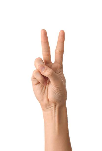 Mano femenina mostrando gesto de victoria sobre fondo blanco - Foto, Imagen