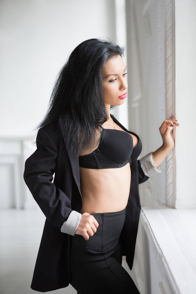 Pensive sexy brunette in black bra posing near window - Zdjęcie, obraz