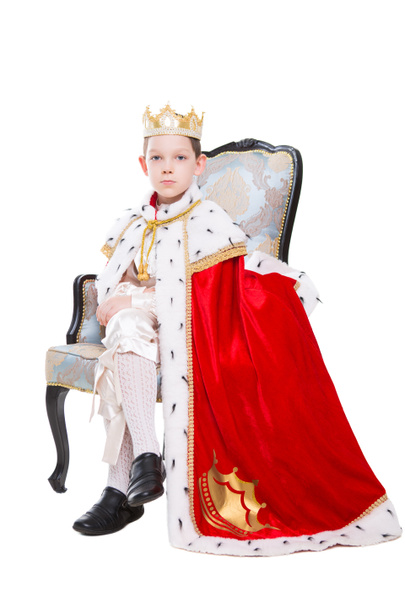 Мальчик в костюме короля и позирует на троне. Изолированные на белом
 - Фото, изображение