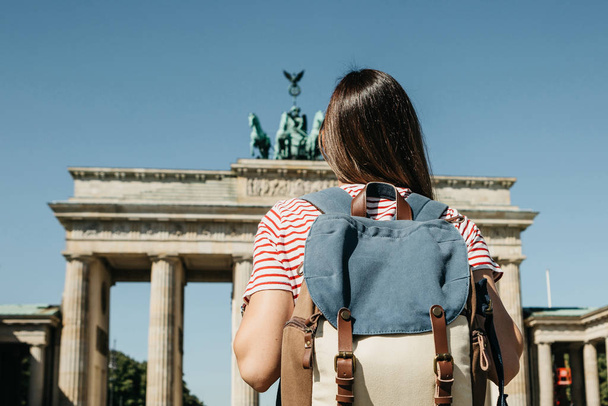 Турист или студент с рюкзаком у Бранденбургских ворот в Берлине в Германии
. - Фото, изображение