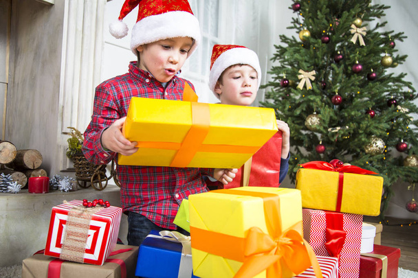 Δύο αγόρια το παιδί με τα Χριστούγεννα παρουσιάζουν κουτί. - Φωτογραφία, εικόνα