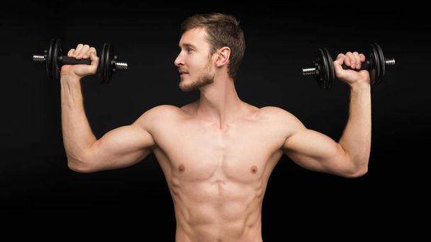 europeu caucasiano atlético homem fisiculturista segurando halteres e mostrando seus braços musculares
 - Foto, Imagem