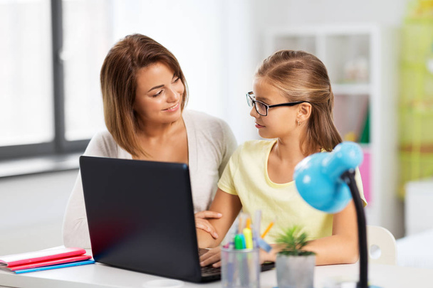 mother and daughter with laptop doing homework - Photo, Image