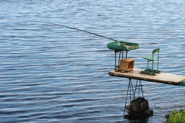 Matériel de pêche, canne avec ligne et bobine. Matériel de pêche laissé sur une plate-forme auto-fabriquée
. - Photo, image