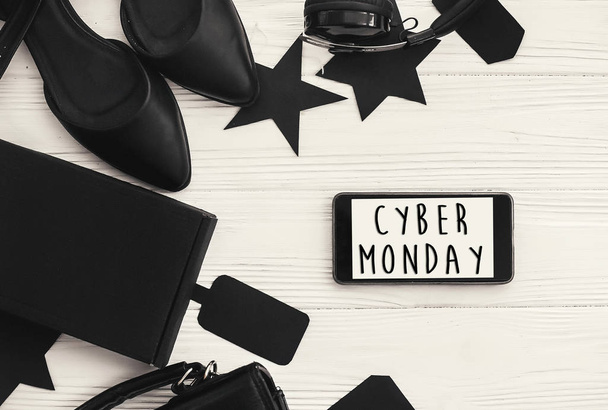 Cyber Monday sale text on phone screen. Special discount christmas offer. Stylish black items, phone with advertising message at gift boxes,price tags,clothes. Shopping time - Foto, immagini