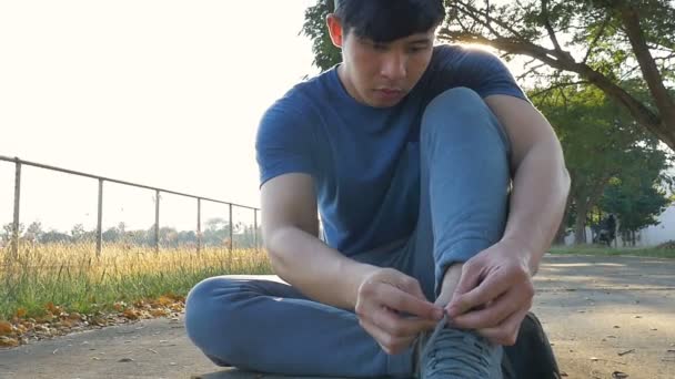 Young Asian man putting on pair of shoes, Tie the laces on the shoes, Slow motion - Filmagem, Vídeo