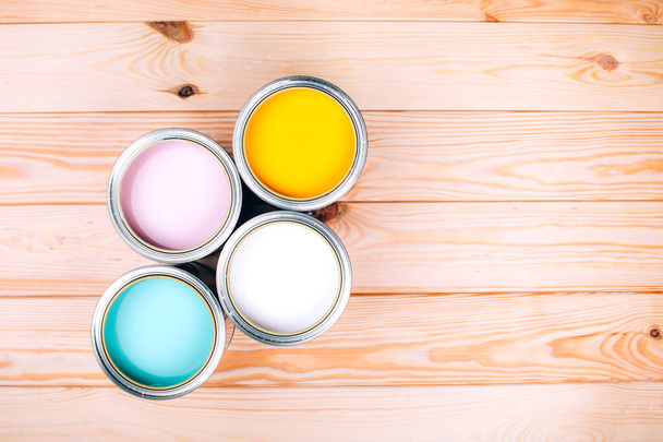 Four open cans of paint on wooden natural background. - Foto, immagini