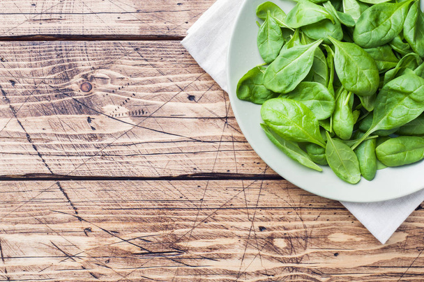 Fresh spinach leaves in bowl on rustic wooden table Copy space - Fotografie, Obrázek