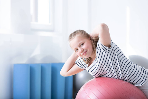 Girl exercising on a fitness ball during a rehabilitation - Fotografie, Obrázek