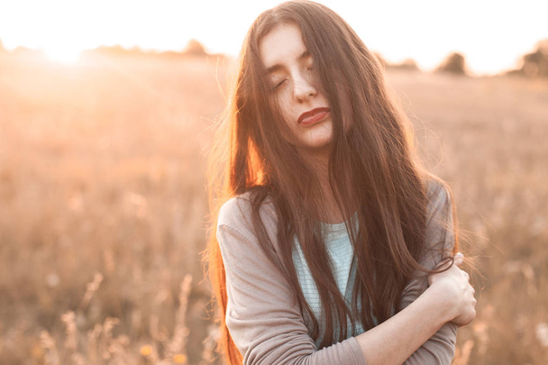 Portrait of the young woman outdoors at sunset - Foto, Imagem