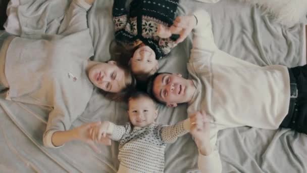 Šťastná rodina vyhledávání kamera na posteli - Záběry, video