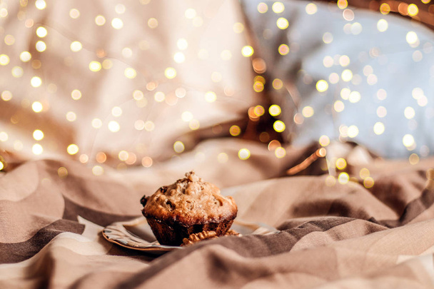 Delicious fresh cupcake with  nut on a plate in bed.  - Фото, изображение