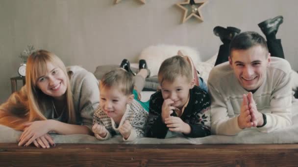 Кавказький родини з двома дітьми, щасливі і посміхаючись на ліжка - Кадри, відео