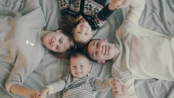 Retrato de uma família caucasiana com dois filhos, feliz e sorridente na cama
 - Filmagem, Vídeo