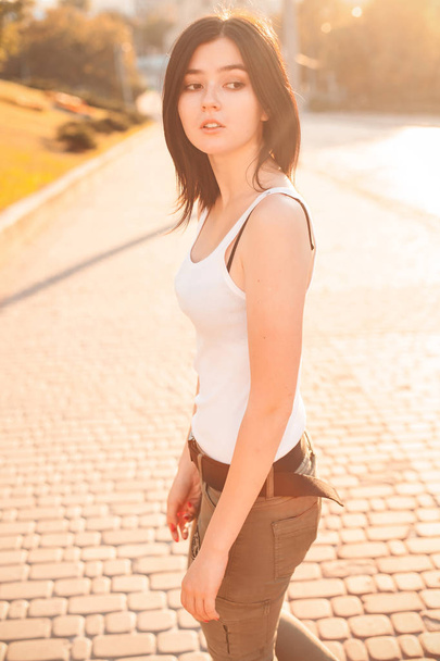 Joven hermosa mujer caminando en la ciudad bajo la luz del sol
 - Foto, Imagen