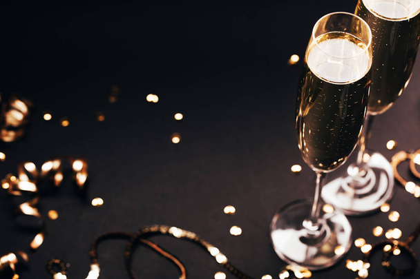 Two glasses of champagne with decoration on black elegant background. - Фото, зображення