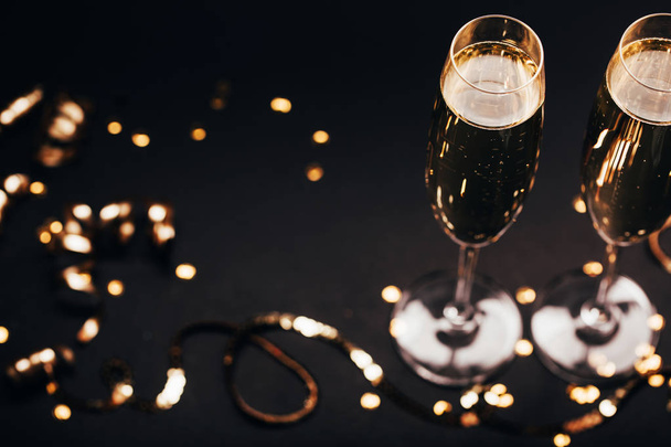 Dos copas de champán con decoración sobre fondo negro elegante
. - Foto, imagen