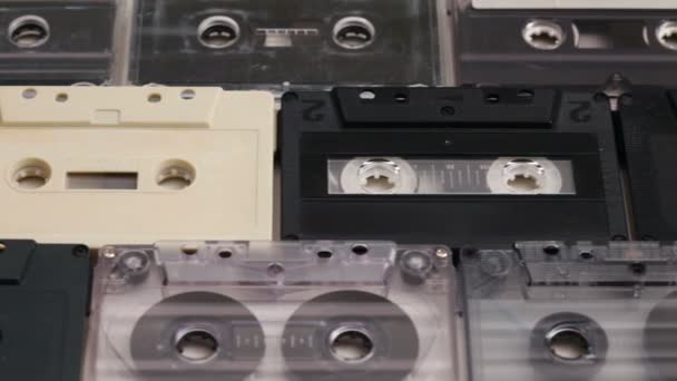 Retro musiikki kompakti kasetit riveissä pöydällä, kamera hitaasti liukuu edellä, sivunäkymä
 - Materiaali, video