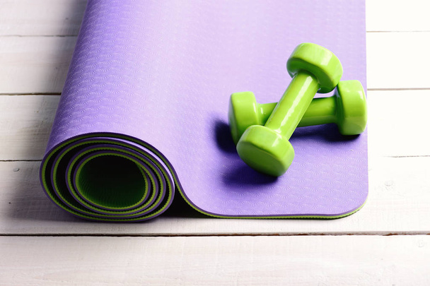 Sports and healthy lifestyle concept. Barbells on purple yoga mat - 写真・画像
