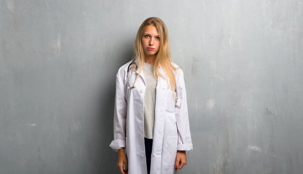 Young doctor woman with sad and depressed expression. Serious gesture - Fotografie, Obrázek