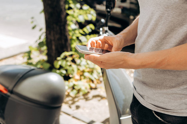 Турист або хлопець використовує мобільний телефон на міській вулиці
 - Фото, зображення