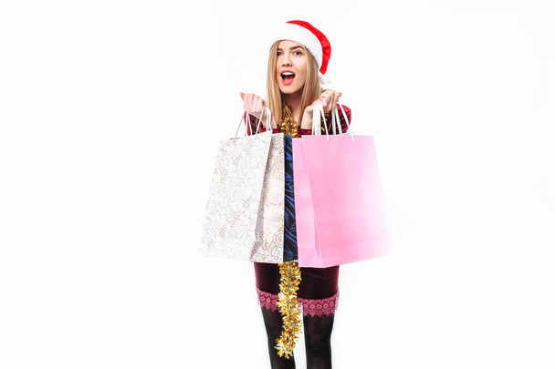 Girl in a Santa hat, with Christmas bags in their hands. On a white background. - 写真・画像