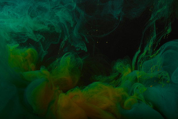close up view of abstract background with green and orange swirls of paint  - Photo, Image