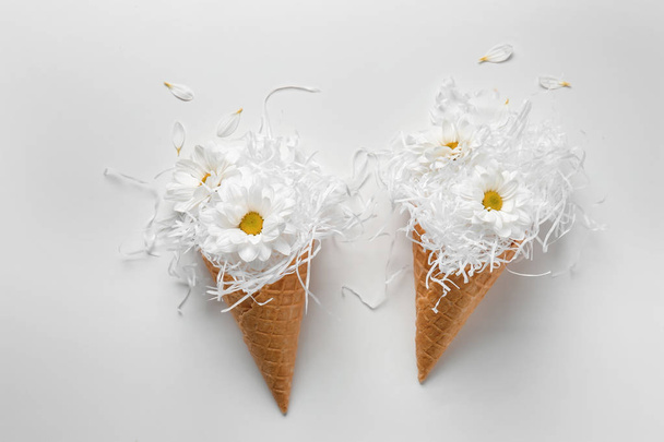Waffle cones with paper strips and flowers on white background - Photo, image