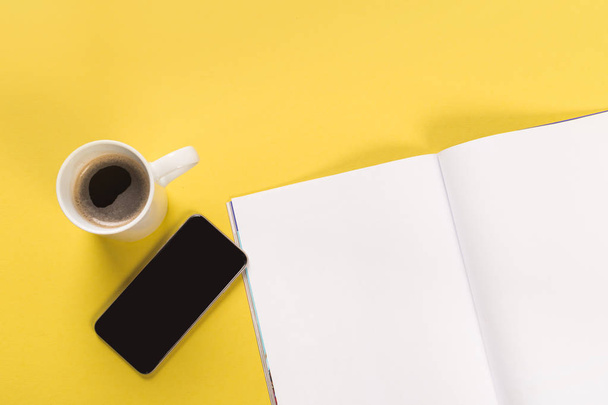 Phone, coffee and mock up magazine on yellow background - Zdjęcie, obraz