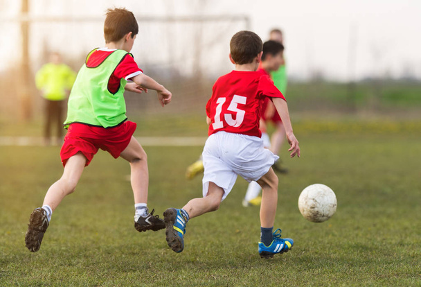 Fiatal gyerekek játékos a labdarúgó-mérkőzés mező - Fotó, kép