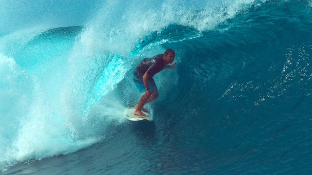 CERRAR: El experimentado surfista masculino es casi barrido por una gran ola de cañón cristalino que se enrolla sobre su cabeza mientras practica surf en la hermosa Polinesia Francesa. Jinete captura una impresionante onda de tubo de color turquesa
. - Foto, imagen