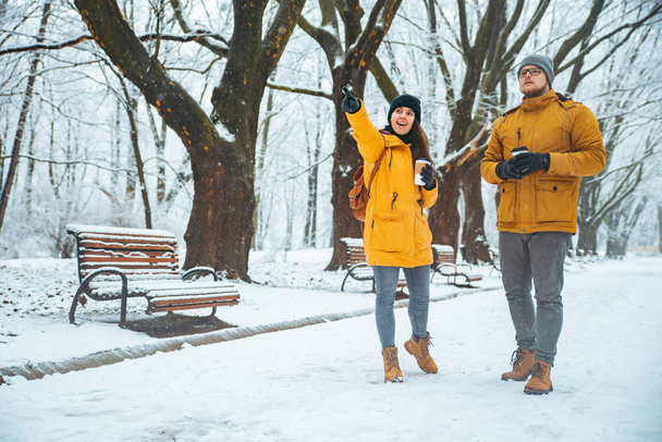 пара, гуляющая по снежному городскому парку и общающаяся. романтическое свидание зимой. Рождество грядет
 - Фото, изображение