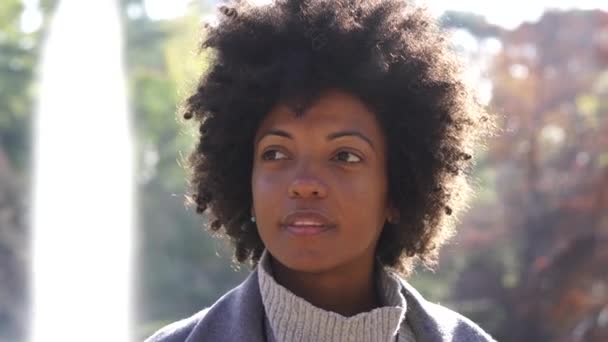 Portret atrakcyjne kobiety afro przy użyciu telefonu komórkowego na ulicy - Materiał filmowy, wideo