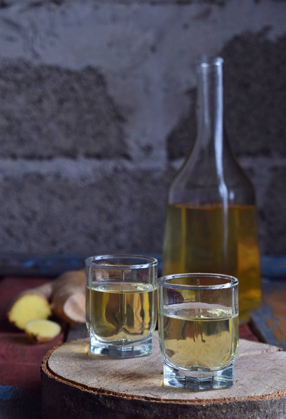 Zencefil tentür veya ahşap arka plan ale. Bir cam baharat sarı likör. Ev yapımı alkol içki. Rustik tarzı - Fotoğraf, Görsel