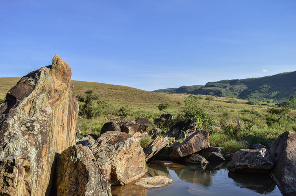 paisaje de un rio con piedras y colinas - Foto, afbeelding