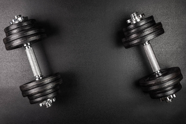 Gym dumbbells on black background with copy sapce, Photograph taken from above. - Foto, Imagem