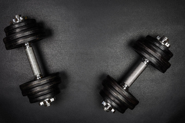 Gym dumbbells on black background with copy sapce, Photograph taken from above. - Foto, afbeelding